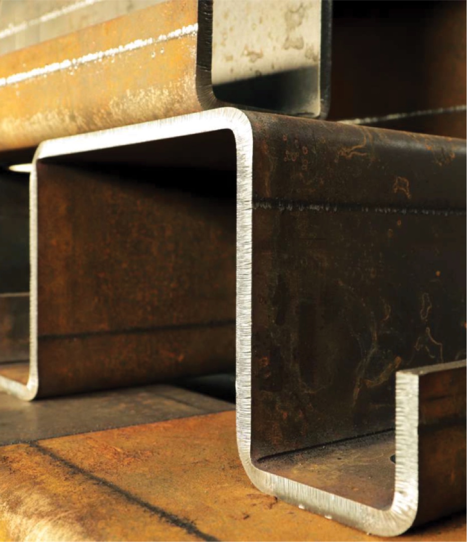 Close-up view of stacked rusted steel beams with a U-shaped profile.